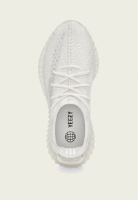 Tênis de malha brancos com um superior texturizado, fecho com atacadores e sola de borracha semi-translúcida. Apresenta a marca "YEEZY" na palmilha.