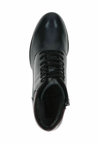 Bottine en cuir noir à bout rond, à lacets et avec zip sur le côté. La doublure intérieure est douce et de couleur sombre.