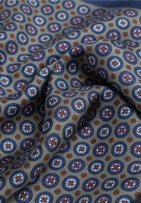 Tessuto a fantasia con motivi circolari in blu, viola e rosso, con un design floreale su uno sfondo grigio; texture morbida.