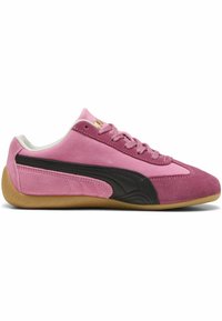 Niedrig geschnittene rosa Wildledersneaker mit schwarzem Seiteneinsatz, Gummisohle und rosa Schnürsenkeln, aus seitlicher Ansicht gezeigt.