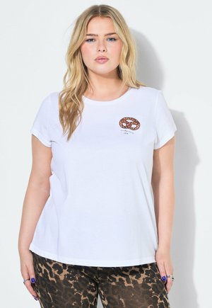 T-shirt bianco in cotone con maniche corte, caratterizzato da una grafica di un pretzel marrone sul petto. Abbinato a leggings con stampa animale.