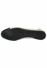 Black rubber outsole with a textured pattern. Cream sidewalls with a smooth finish. Subtle stitching along the edge.