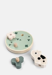 Conjunto de juguetes de madera con una base redonda verde que presenta clavijas, una flor color crema, una mariposa en forma de color verde y una vaca color crema con manchas negras.