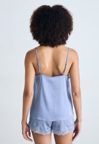 Light blue satin camisole and shorts set with adjustable straps and lace trim along the edges. Smooth texture with a relaxed fit.
