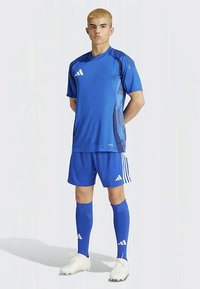 Blå idrettstrøye med korte ermer, matchende shorts og sokker; har hvite Adidas-logoer og et strukturert design på sidene.