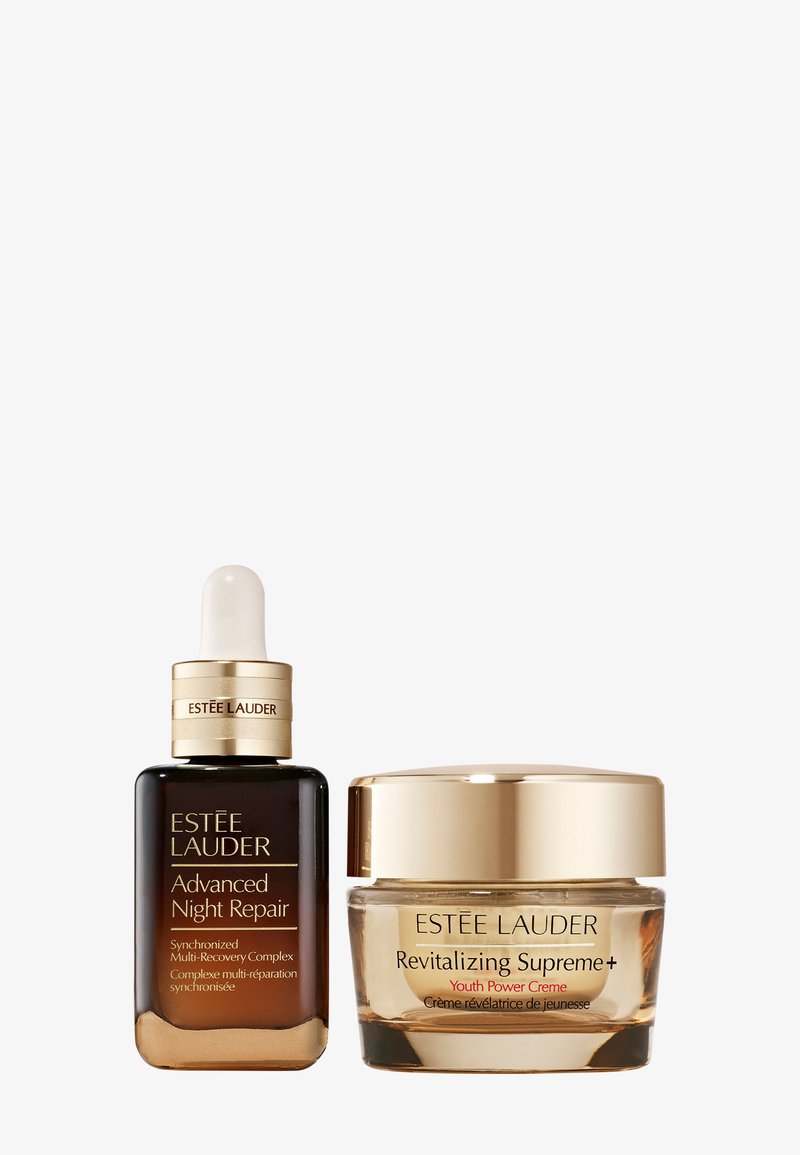 Estee Lauder Hautpflege-Duo: eine braune Glasflasche mit einem Tropferkopf und ein Cremetiegel mit einem goldenen Deckel. Beide tragen Markenetiketten in goldener Schrift.