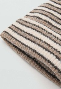 Villahuivi, jossa on beigeitä ja tummanruskeita vaakaraitoja, teksturoitu neulos ja taitettu reuna, antaen pehmeän ja lämpimän vaikutelman.