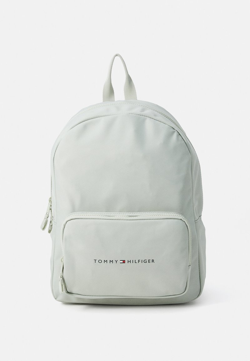 Light green backpack in durable fabric with a smooth texture. Features a front zip pocket, a top handle, and printed logo on the front.
