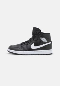 Schwarze Leder-Hochschnitt-Sneaker mit weißen Akzenten, durchlöchertem Zehenbereich und auffälligem Branding an der Außenseite. Weiße Gummisohle.