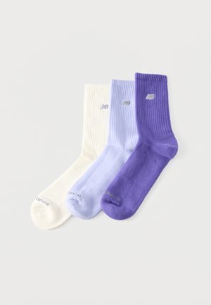 Drei gerippte Crew-Socken in Weiß, Helllila und Dunkellila, jeweils mit einem kleinen gestickten Markenlogo nahe der Oberseite.