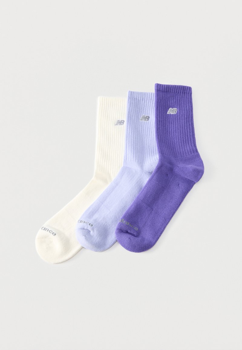 Τρεις κάλτσες με ρίγες σε λευκό, ανοιχτό μωβ και σκούρο μωβ, η καθεμία με ένα μικρό κεντημένο λογότυπο της μάρκας κοντά στην κορυφή.