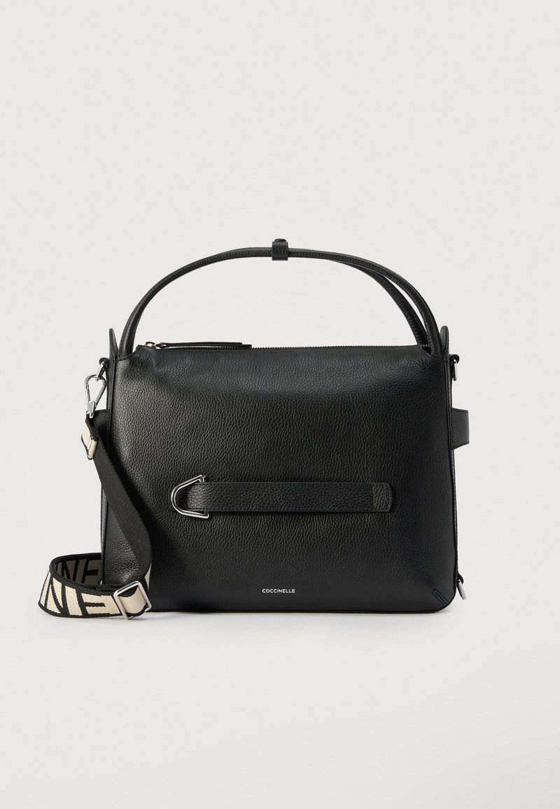 Μαύρη δερμάτινη τσάντα χειρός με επάνω λαβή και αποσπώμενο ρυθμιζόμενο λουρί ώμου σε ασπρόμαυρο σχέδιο, ασημένιο μεταλλικό υλικό και κλείσιμο με φερμουάρ.