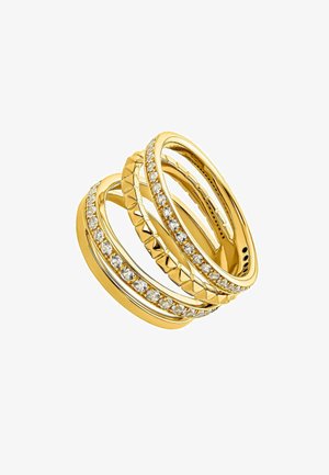 Anillos apilables de oro con diseños texturizados y piedras preciosas transparentes, que exhiben una superficie lisa, patrones geométricos y acabados pulidos.