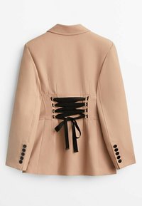 Blazer beige con maniche lunghe, dettaglio in pizzo nero allacciato sul retro e quattro bottoni neri su ciascun polsino.