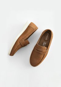 Brązowe buty wsuwane wykonane z zamszu z teksturowaną cholewką, białą gumową podeszwą i akcentowanym przeszyciem. Posiadają dekoracyjny pasek.
