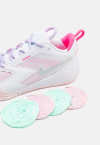 Hvit og rosa joggesko med lyse lilla detaljer og en teksturert såle. Inkluderer mintgrønne og rosa snøringer ved siden av skoen.