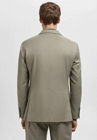 Light gray tailored suit jacket with a standard collar. Smooth texture, slim fit, and minimal stitching details on the cuffs and back.