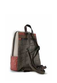 Brauner und beiger Rucksack mit strukturierten Mustern, roten Akzenten und mehreren Reißverschlussfächern. Verstellbare Träger und doppelte Griffe inklusive.