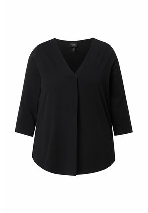 Černý top s tříčtvrtečními rukávy, výstřihem do V a volným střihem. Vyrobený z měkkého materiálu s jemným splýváním a bez viditelných zapínání.