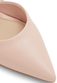 Pump a punta realizzata in pelle liscia color blush con un design a taglio, che mette in mostra un interno morbido e una suola marrone chiaro testurizzata.