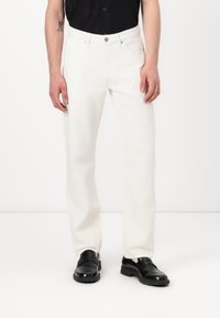 Jeans de mezclilla blanca con corte recto, que presentan un estilo de cinco bolsillos, cierre de botón metálico y detalles de costura sutiles.