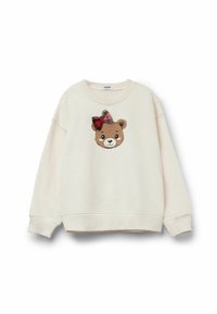 Felpa color crema con scollo rotondo, caratterizzata da un'applicazione a forma di volto di orso con un fiocco a quadri rossi e neri sulla fronte.