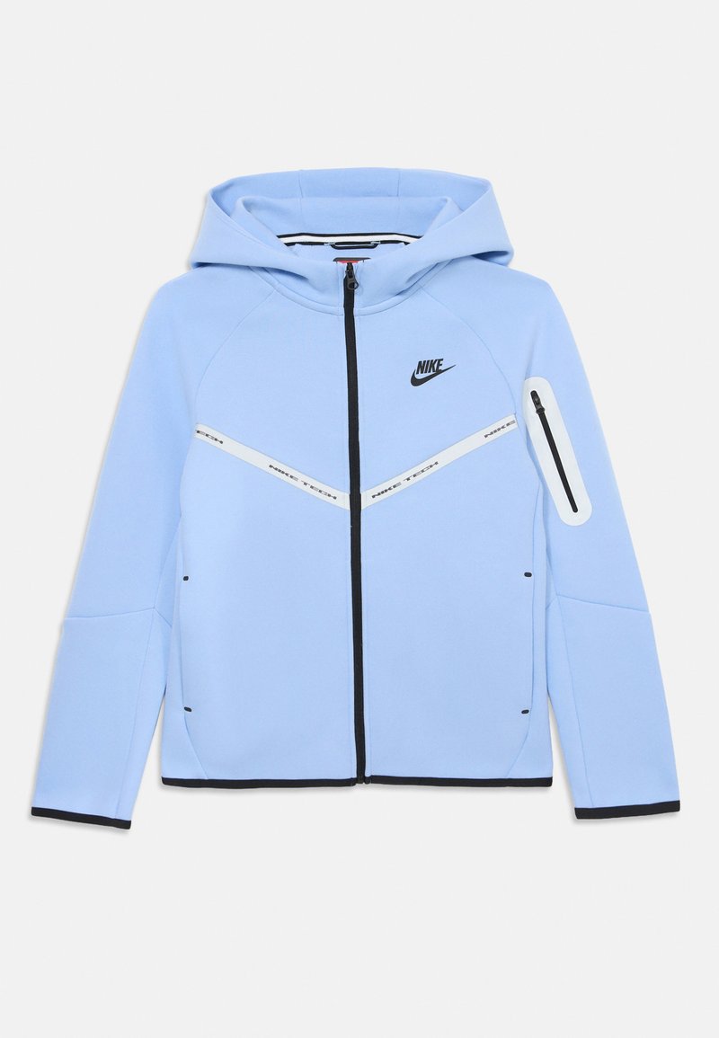 Svijetloplava Nike dukserica s punim prednjim zatvaračem, crnim detaljima i dijagonalnom bijelom prugom preko prsnog dijela. Ima džep s zatvaračem na ruci.