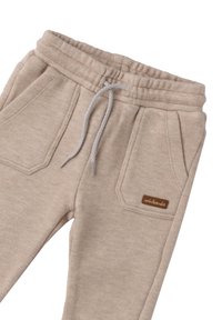 Beige Sweatpants aus weichem Material, mit einem elastischen Bund und Kordelzug, zwei seitlichen Taschen und einem braunen Markenlabel.