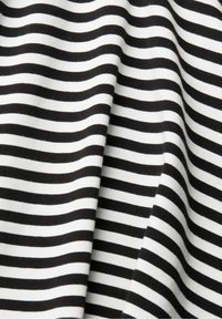 Tela a rayas en blanco y negro con una textura suave. Las rayas están espaciadas de manera uniforme, creando un patrón lineal consistente a lo largo del material.