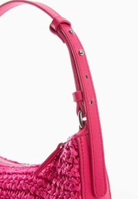 Borsa a tracolla rosa intrecciata con un corpo testo, una tracolla in pelle liscia e accessori metallici. Presenta un compartimento con zip per la chiusura.