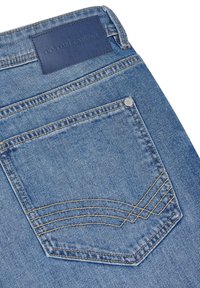 Vaqueros de mezclilla con un parche de cuero azul en la cintura, que presentan un bolsillo trasero con costura diagonal sutil y un hilo dorado en contraste.