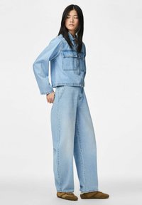 Hele sinise värvusega teksajakk ja laiade säärtega teksad mugavas lõikes. Jakil on kaks rindtaskut; teksad on kõrge vöökohaga.