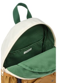 Backpack with a cream exterior, green interior lining, and a zipper closure. Features a green handle and a small label inside.