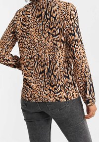 Långärmad skjorta med leopardmönster i nyanser av brunt och svart, tillverkad av ett slätt och lätt tyg.