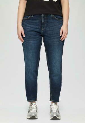Jeans en denim délavé noir avec une coupe droite, un léger effet délavé, des poches avant et des coutures contrastées. Assortis avec des chaussures de sport argentées.