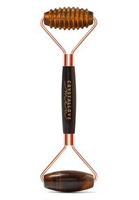 Kryształowy wałek do twarzy z brązową teksturowaną głowicą, miedzianymi akcentami oraz gładkim czarnym uchwytem z napisem "CRYSTALLOVE" w kolorze złotym.