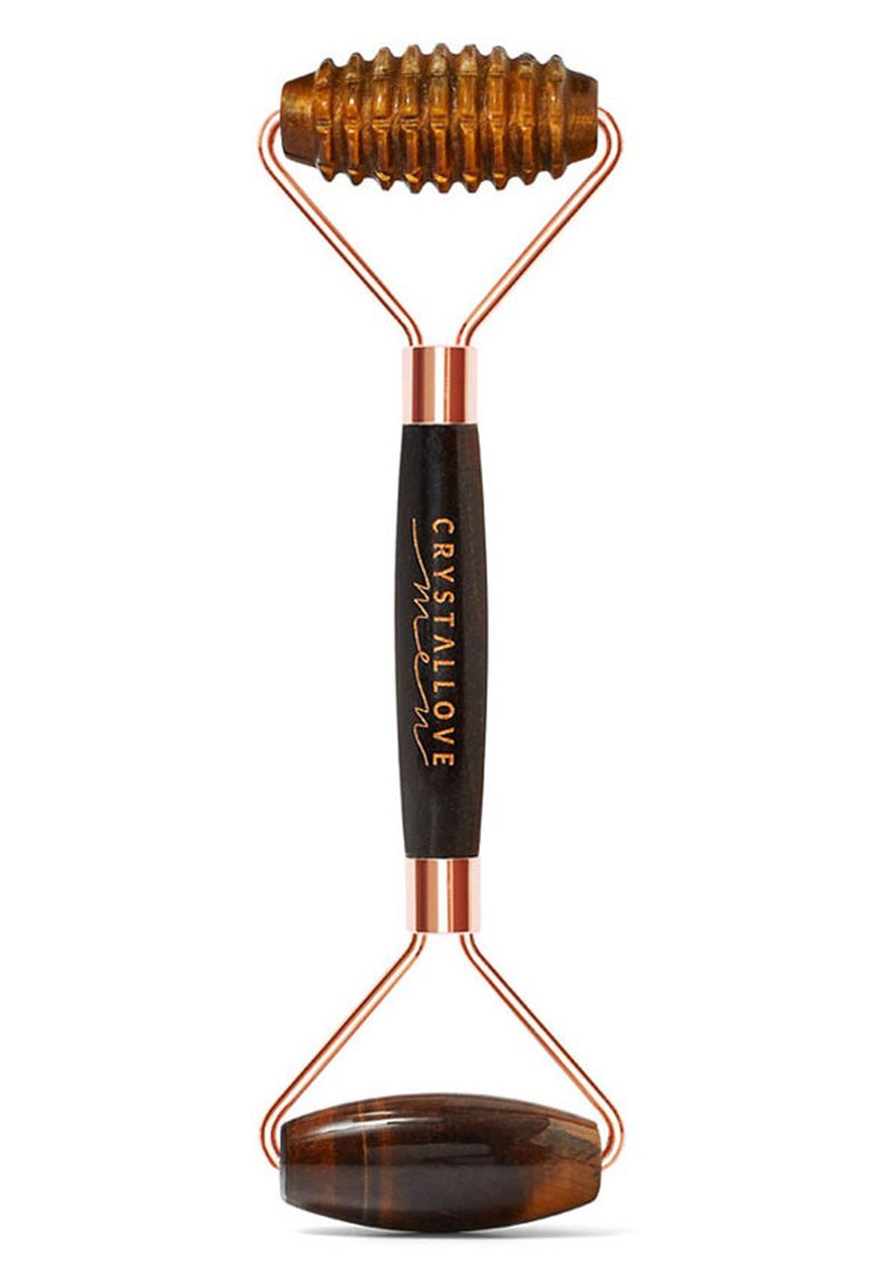 Kryształowy wałek do twarzy z brązową teksturowaną głowicą, miedzianymi akcentami oraz gładkim czarnym uchwytem z napisem "CRYSTALLOVE" w kolorze złotym.