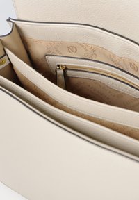 Beige lædertaske med flere rum, glat tekstur og lys indvendig med et logomønster. Guld lynlås og hardware-accenter.