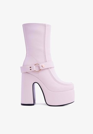Stivaletto alla caviglia rosa con piattaforma, realizzato in materiale sintetico liscio. Presenta un tacco largo, una punta arrotondata e una cinghia decorativa con una fibbia color oro.