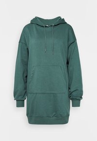 Zelená oversized mikina vyrobená z měkké látky, která má přední kapsu, kapuci se šňůrkou a ribbené manžety a lem.