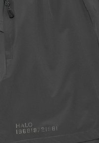 Czarna wodoodporna kurtka z gładką fakturą, z kieszeniami na zamek oraz nadrukowanymi detalami "HALO 196819721981" u dołu.