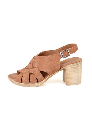 Sandale à talon en suede marron avec des brides croisées, bout ouvert, sangle de cheville réglable et un talon en bois clair texturé.