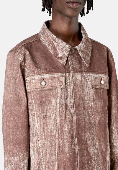 Brown denim jacket with a textured finish, featuring a pointed collar, two front pockets, and silver hardware accents.