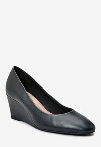 Scarpa con tacco a cuneo in pelle nera, punta affusolata, texture liscia e una piattaforma bassa. L'interno presenta una morbida fodera beige per il massimo comfort.