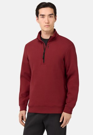 Sweatshirt bordeaux en polaire avec un col zippé à quart, des poignets et un ourlet côtelés. Fabriqué dans un tissu doux avec une texture lisse et des poches latérales.