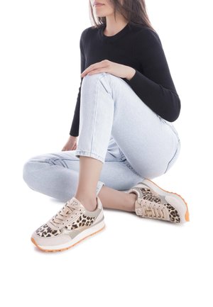 Zapatillas con parte superior en beige y estampado de leopardo, detalles metálicos y suelas de goma naranjas; diseño con cordones y material texturizado.
