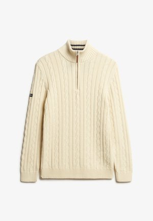 Kabelstrikket creme sweater med høj krave, halvdels lynlås, ribbet bund og manchetter, tekstureret mønster og med diskret branding på ærmet.