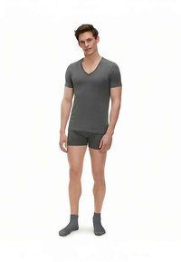 Maglietta grigia a scollo a V e boxer abbinati realizzati in tessuto morbido, abbinati a calzini alla caviglia grigio scuro. Design semplice e aderente.