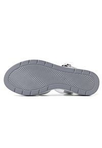 Sola di scarpa in gomma grigia con un motivo a onda e scanalature testurizzate. Presenta bordi arrotondati e nessun marchio visibile o dettagli hardware.