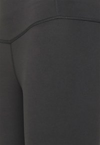 Zwarte leggings van gladde, rekbare stof met platte naden en een medium taille, met een minimalistisch ontwerp zonder zichtbare patronen.